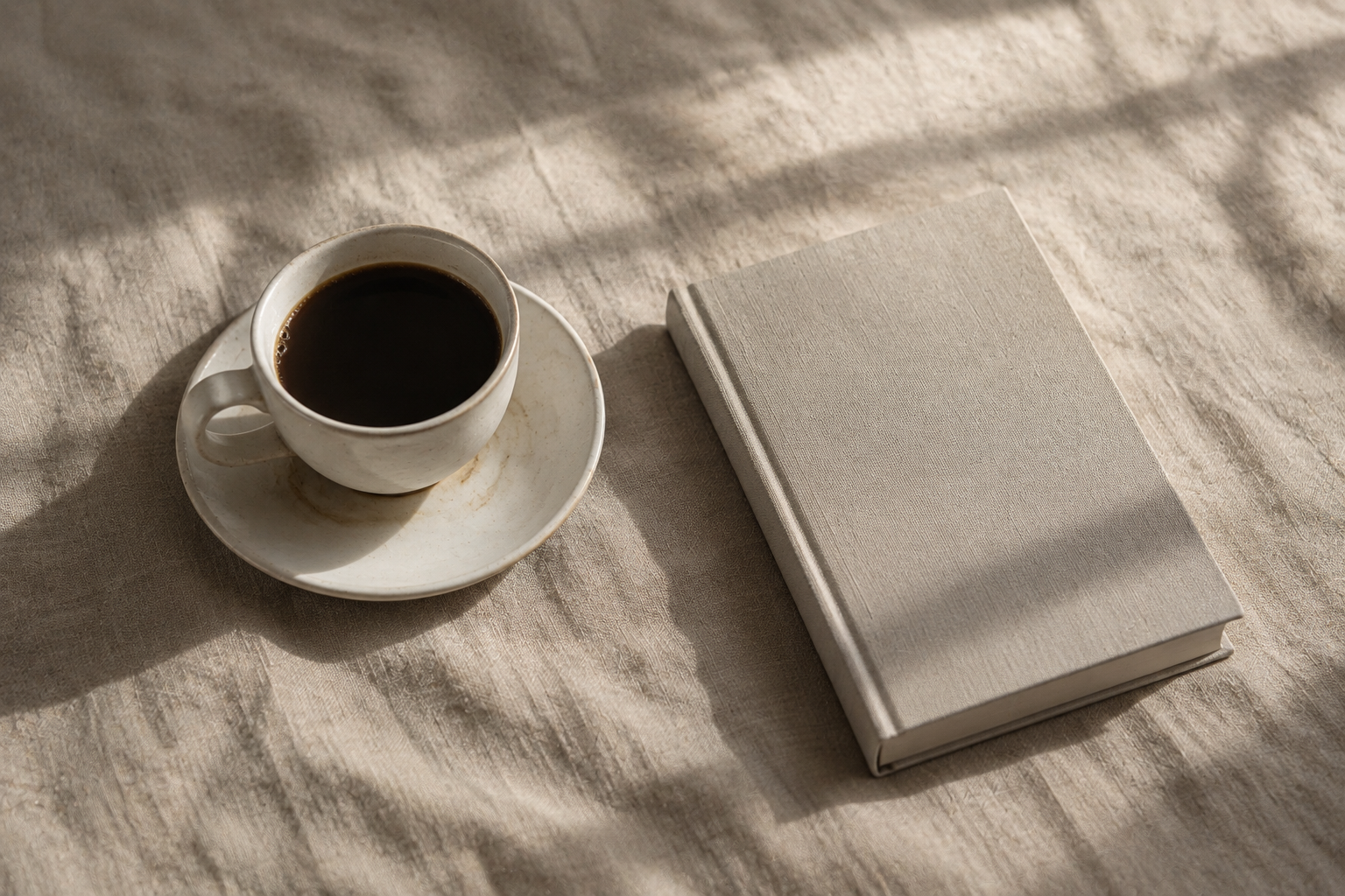 Coffee cup and closed book on linen for the Energy and Insight journal article